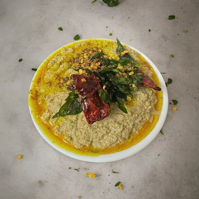 Tangy Tamarind Chutney for Dosa & Idli South Indian tamarind leaf chutney served with idli and dosa, garnished with fried spices