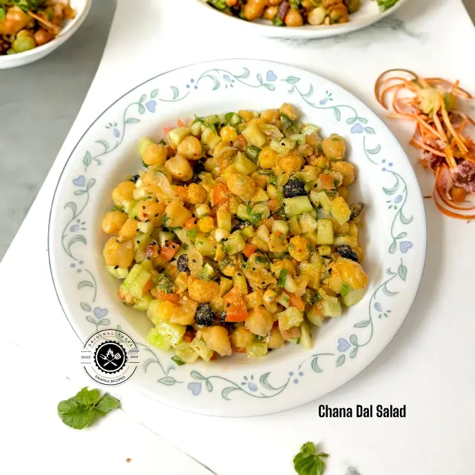 Flavorful chickpea salad tossed with spices, chopped vegetables, and coriander for a perfect light meal or snack.