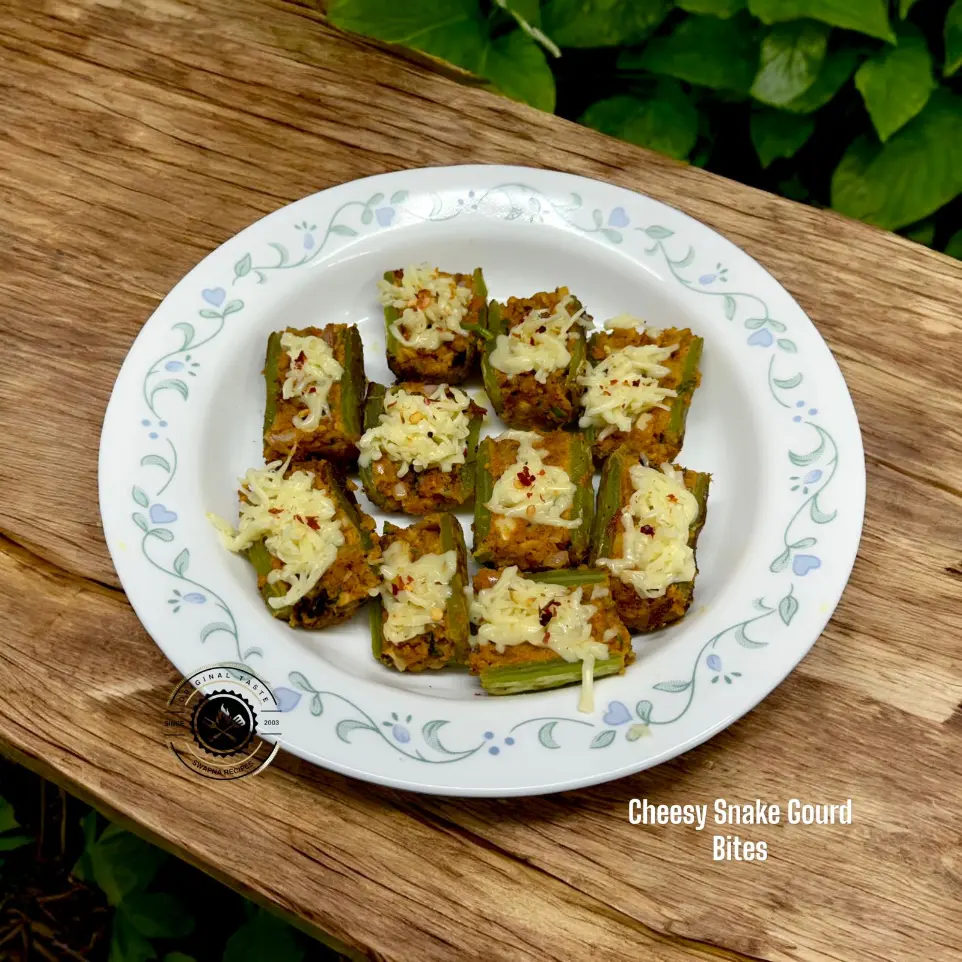 Cheesy stuffed snake gourd boats filled with spicy sesame coconut masala and topped with chili flakes and melted cheese.
