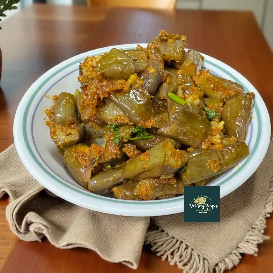 A pan-fried brinjal curry cooked with garlic peanut masala and curry leaves, served hot with roti or rice for a bold and spicy vegetarian meal.