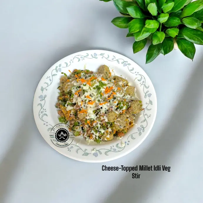 Colorful millet idli stir-fry tossed with crunchy veggies, spices, and crowned with cheese—an easy fusion of taste and health on your plate.