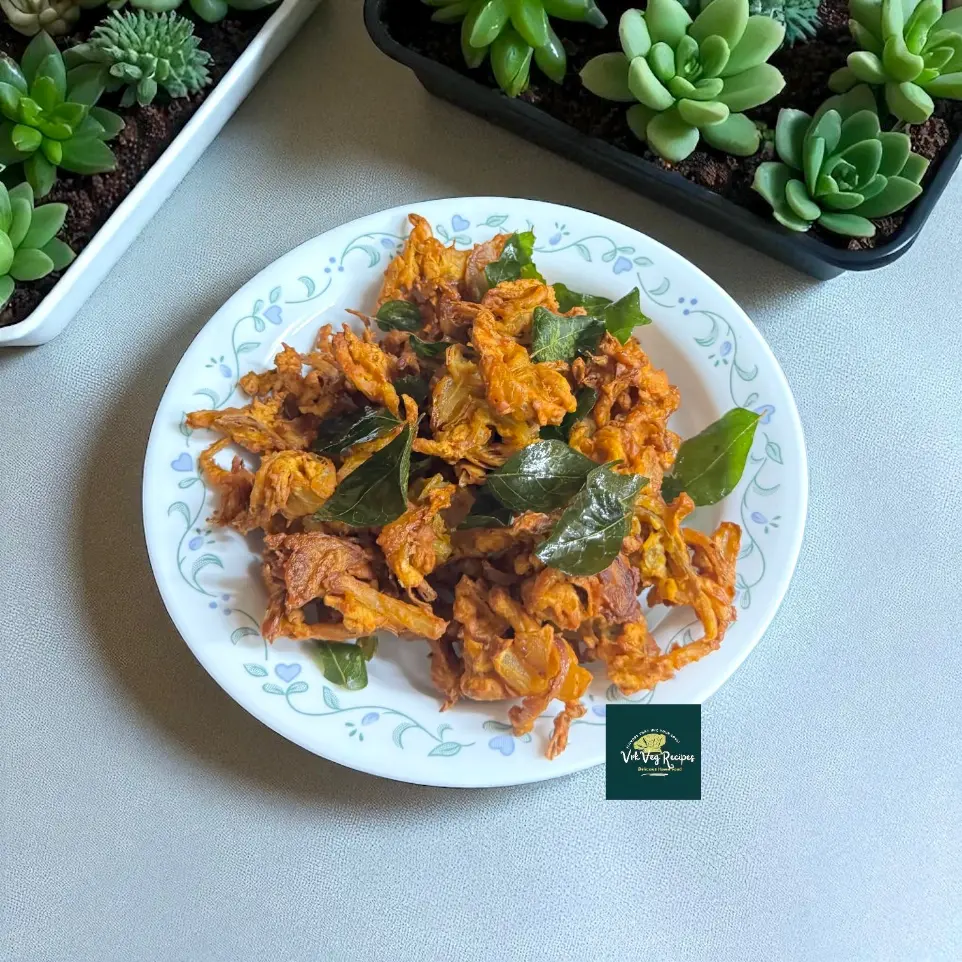 Hot onion pakoda: thin onion strands in besan, fried shatter-crisp, sprinkled with curry leaves and served with green chutney—classic monsoon snacking.