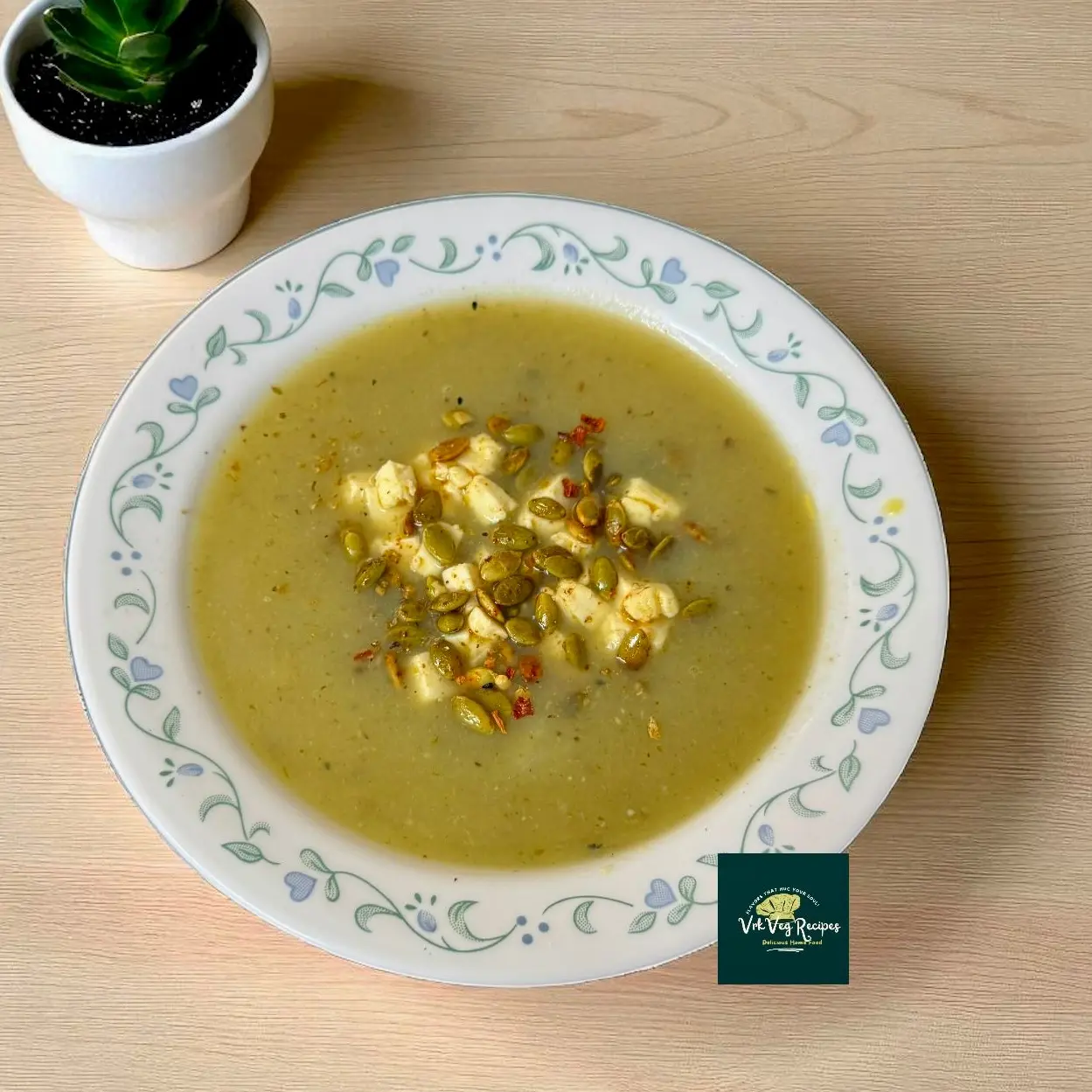 Bowl of bottle gourd garlic soup topped with fried paneer cubes, roasted pumpkin seeds, and a sprinkle of red chilli flakes served hot.